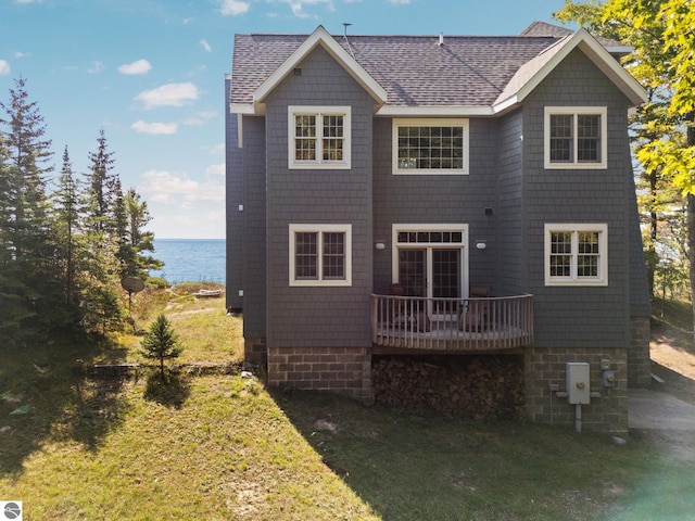 rear view of property featuring a deck and a yard