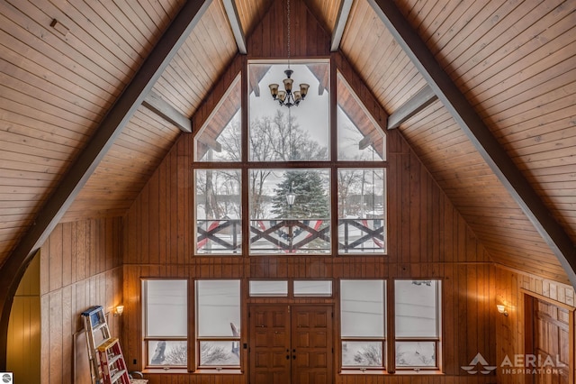 interior details featuring wood walls, wood ceiling, a notable chandelier, and beam ceiling