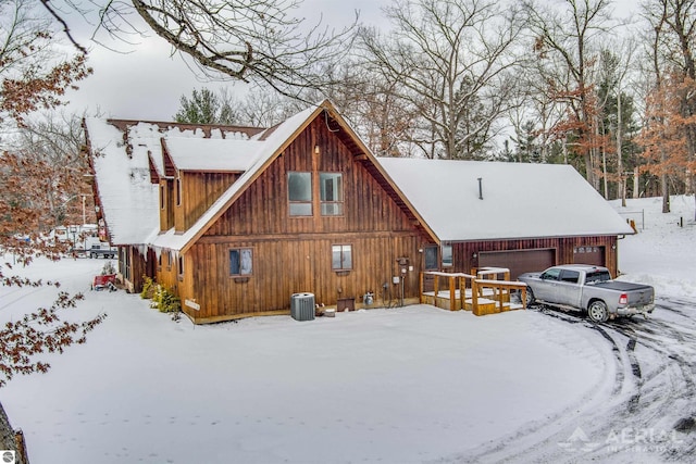 snow covered property with a garage