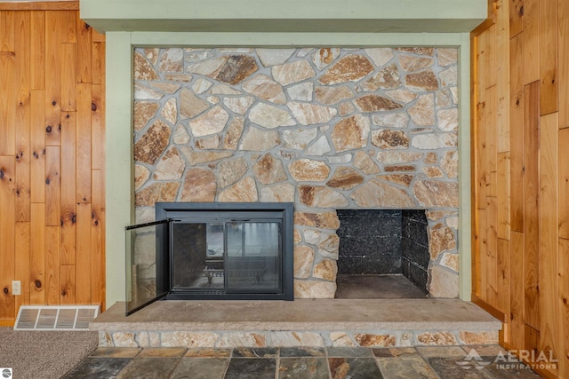 details featuring carpet floors, wood walls, and a fireplace