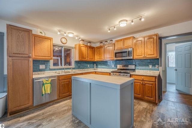 kitchen featuring stainless steel appliances, sink, butcher block counters, a center island, and hardwood / wood-style floors