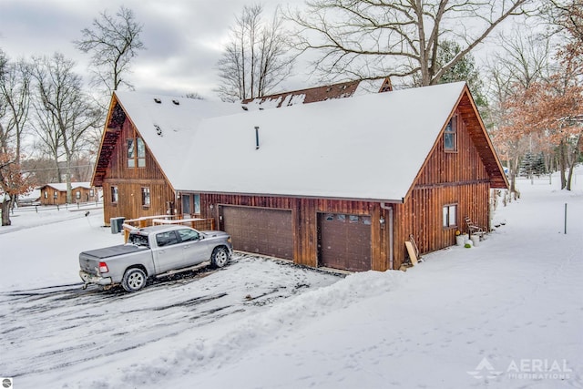 view of snowy exterior with a garage