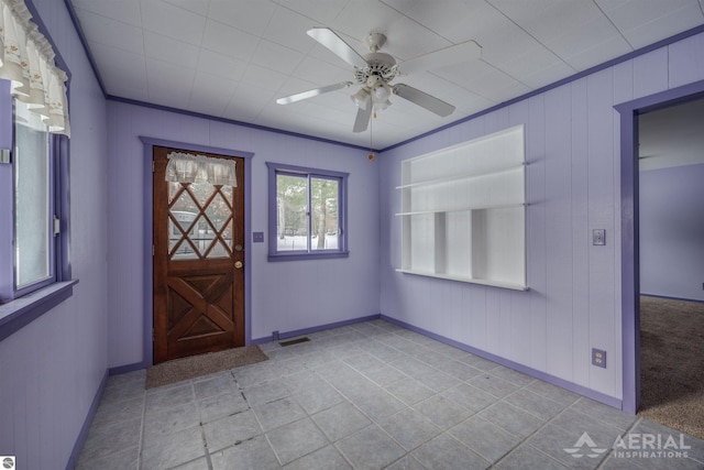 entryway featuring ceiling fan and crown molding