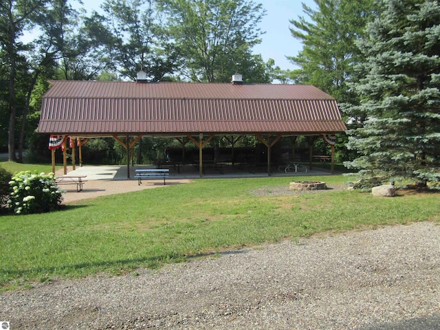 view of home's community with an outdoor fire pit and a lawn