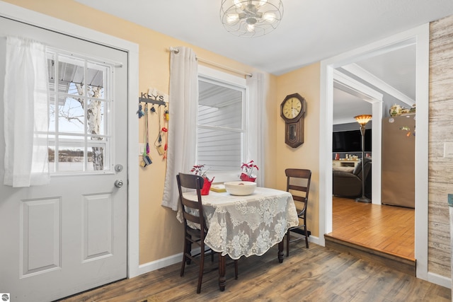 dining space featuring dark hardwood / wood-style floors and an inviting chandelier