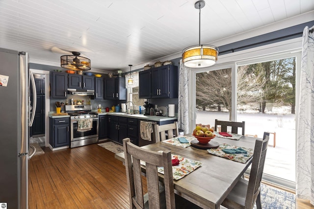 kitchen featuring decorative light fixtures, dark hardwood / wood-style floors, sink, appliances with stainless steel finishes, and ornamental molding