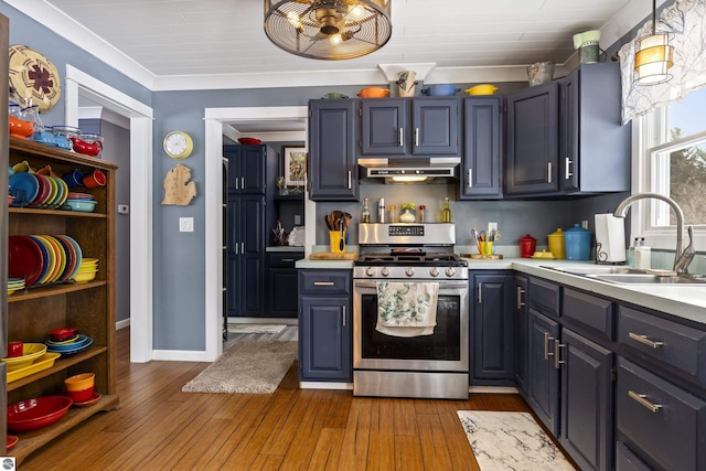 kitchen with pendant lighting, extractor fan, sink, dark hardwood / wood-style floors, and stainless steel range with gas cooktop