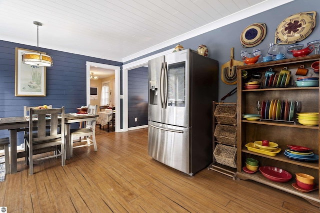 kitchen with wood-type flooring, crown molding, hanging light fixtures, stainless steel fridge, and wooden ceiling