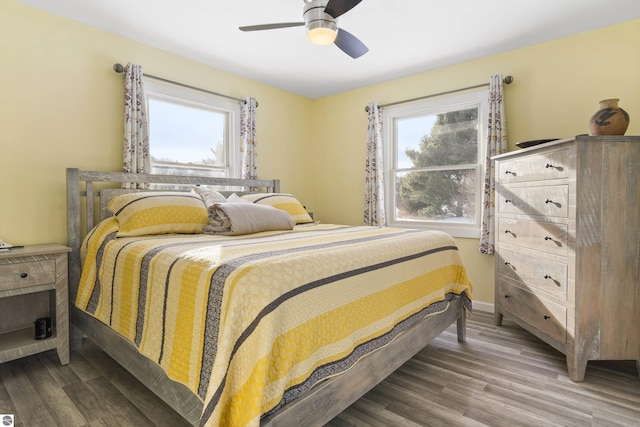 bedroom with ceiling fan, hardwood / wood-style flooring, and multiple windows