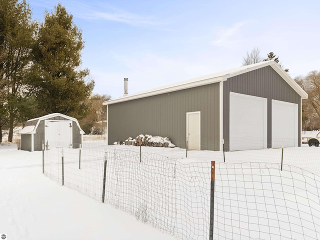 snow covered structure featuring a garage