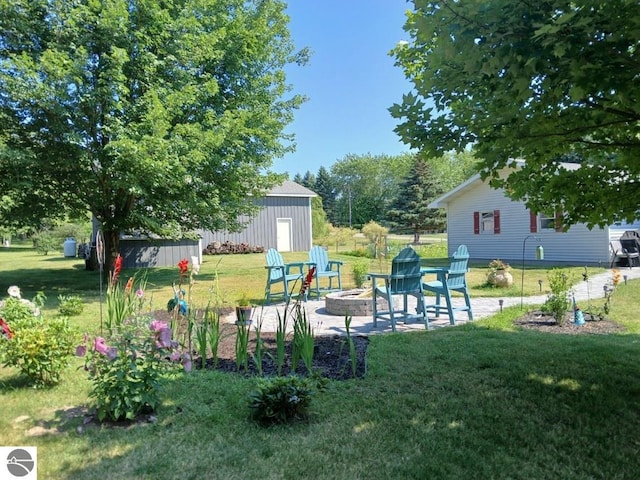 view of yard with an outbuilding, an outdoor fire pit, and a patio