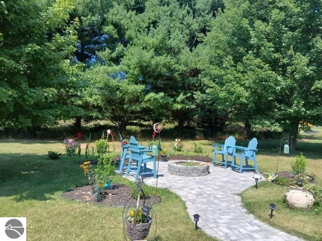 surrounding community featuring a lawn, a patio area, and a fire pit