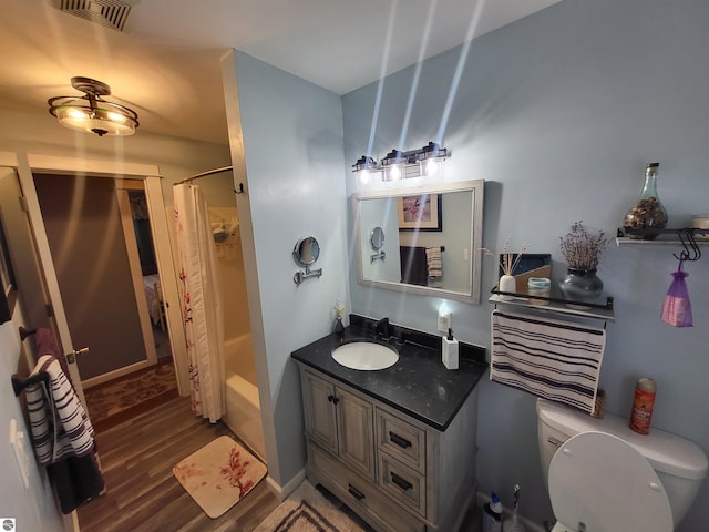 full bathroom featuring toilet, hardwood / wood-style flooring, vanity, and shower / tub combo with curtain