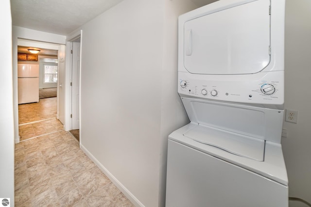 clothes washing area with stacked washer / dryer