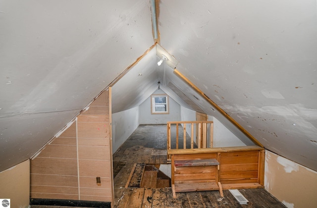 additional living space featuring vaulted ceiling and dark wood-type flooring