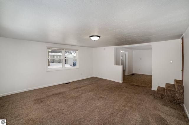 unfurnished room featuring a textured ceiling and carpet