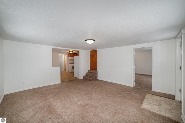 carpeted spare room with a textured ceiling