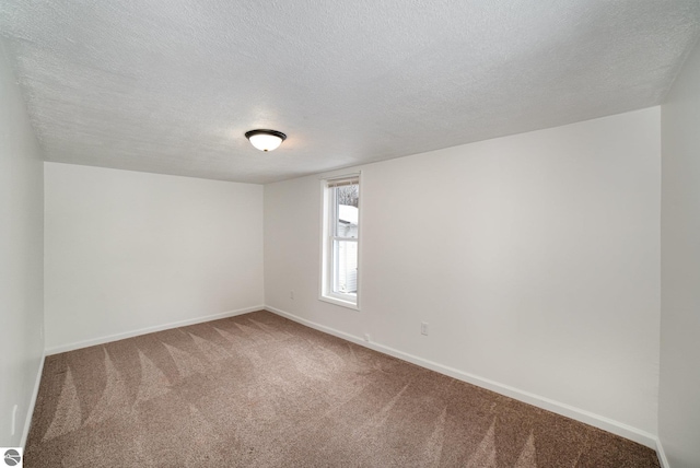 carpeted spare room with a textured ceiling