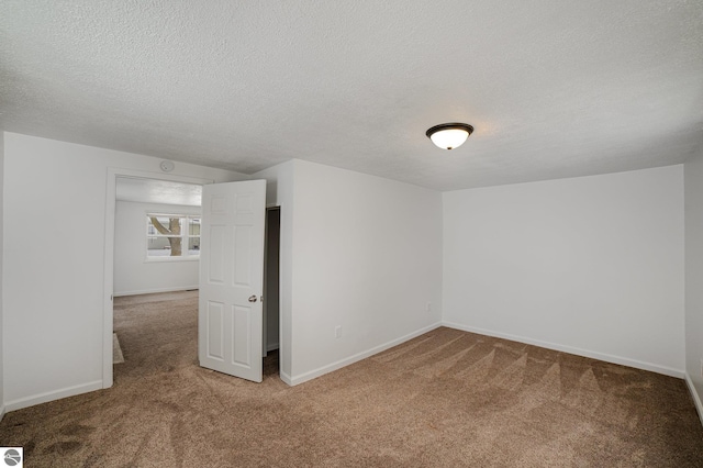 carpeted spare room with a textured ceiling