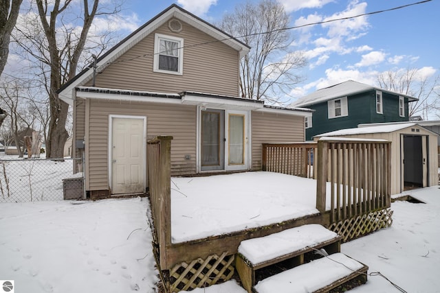 snow covered house with a storage unit