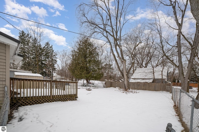 yard covered in snow with a deck