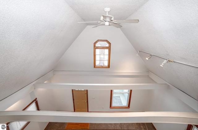 additional living space with ceiling fan, vaulted ceiling, and a textured ceiling