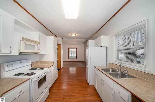 kitchen featuring white cabinetry, white appliances, wood-type flooring, a textured ceiling, and sink