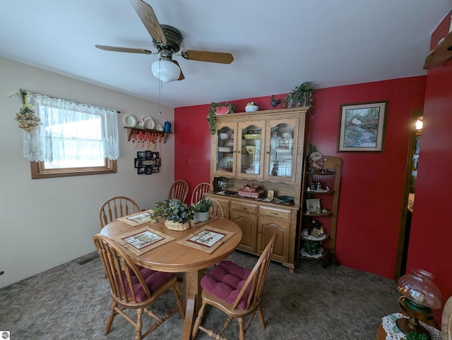 carpeted dining room featuring ceiling fan