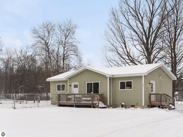 snow covered rear of property with a wooden deck