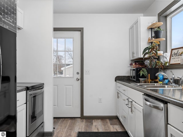 kitchen featuring a wealth of natural light, white cabinets, sink, and stainless steel appliances