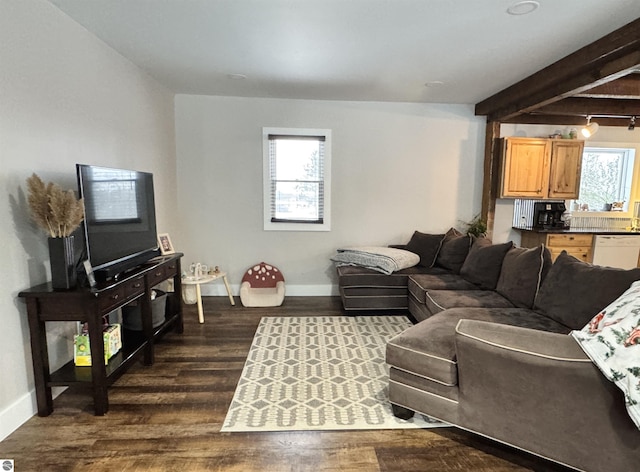 living room with dark hardwood / wood-style flooring and beamed ceiling