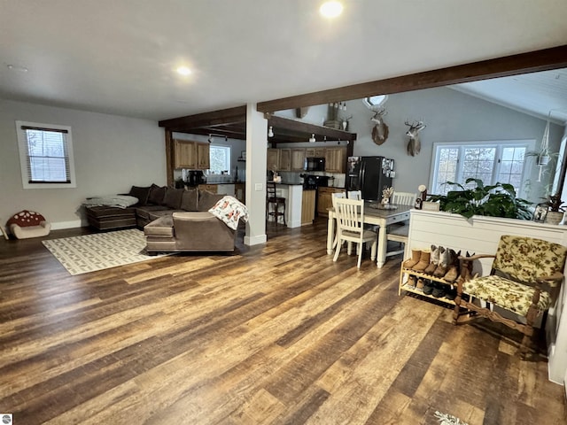 living room featuring plenty of natural light, hardwood / wood-style floors, and vaulted ceiling with beams