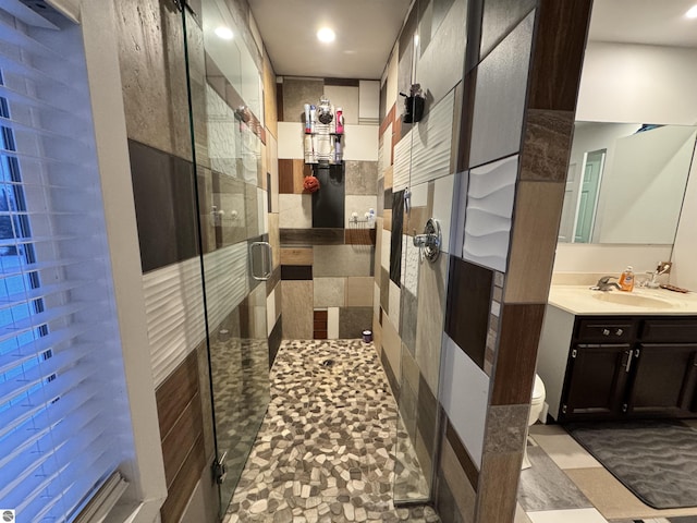 bathroom with walk in shower, vanity, and toilet