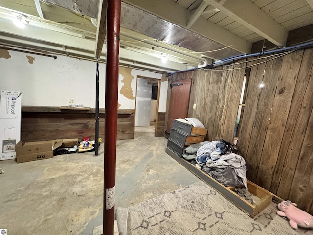 basement featuring wood walls