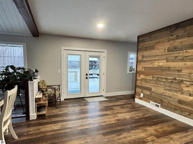 doorway to outside featuring french doors, plenty of natural light, dark hardwood / wood-style flooring, and wood walls