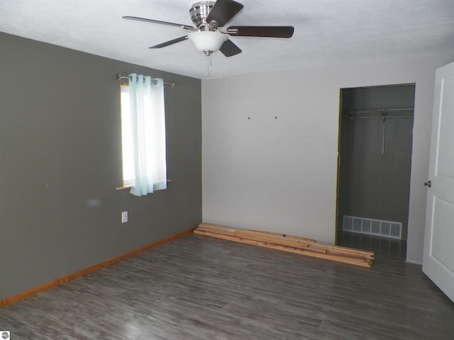 unfurnished bedroom with a closet, dark hardwood / wood-style floors, and ceiling fan