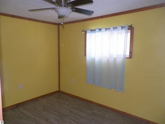 unfurnished room featuring dark wood-type flooring, ceiling fan, and crown molding