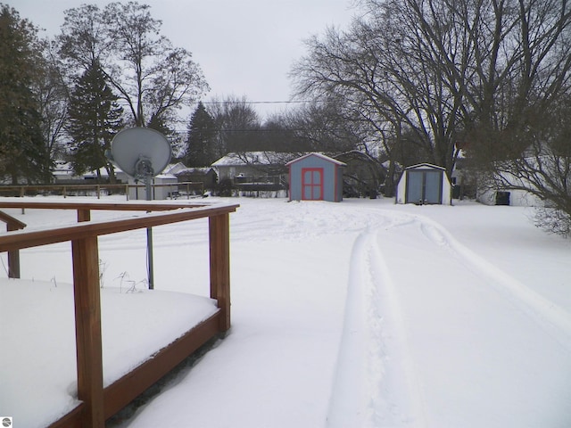 snowy yard with a storage shed