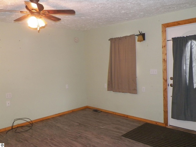 unfurnished room with ceiling fan, dark hardwood / wood-style flooring, and a textured ceiling