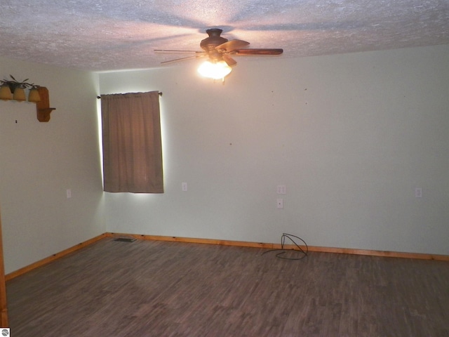 unfurnished room with ceiling fan, dark hardwood / wood-style floors, and a textured ceiling