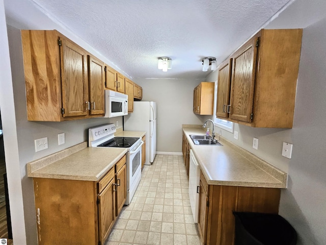 kitchen featuring sink, white appliances, and a textured ceiling