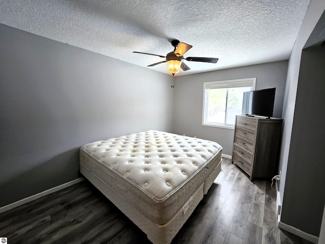 bedroom featuring ceiling fan, a textured ceiling, and dark hardwood / wood-style flooring