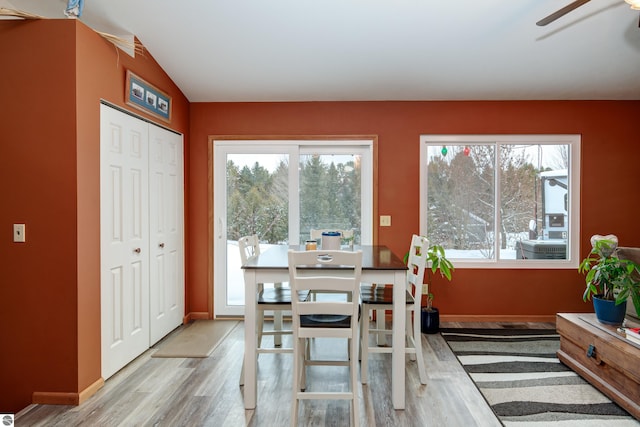 dining room featuring hardwood / wood-style flooring, lofted ceiling, and ceiling fan