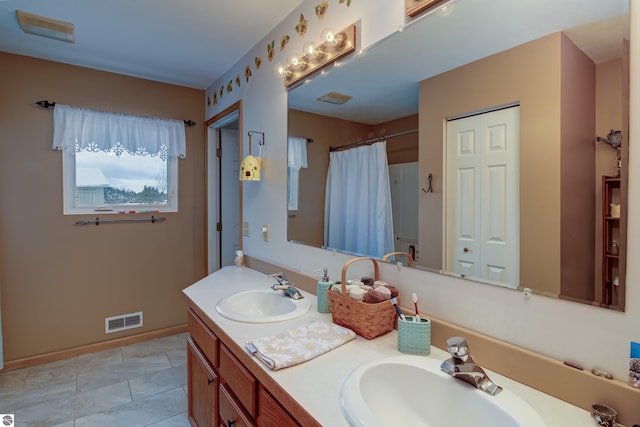 bathroom featuring tile patterned flooring, walk in shower, and vanity