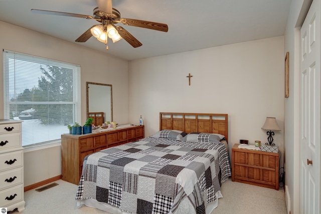 bedroom featuring light carpet, ceiling fan, a closet, and multiple windows