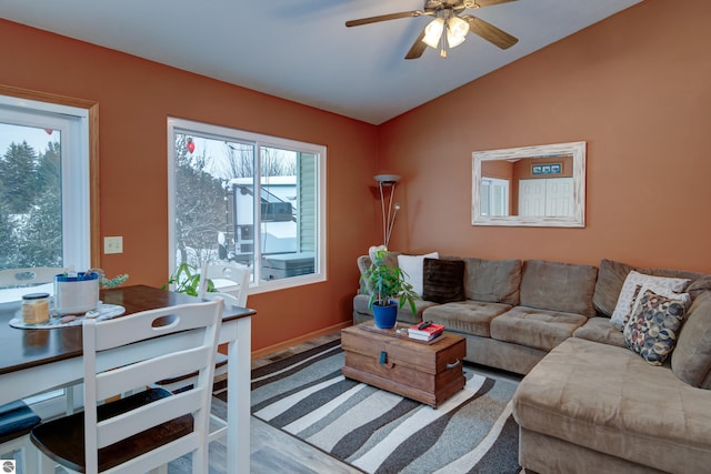 living room featuring ceiling fan, wood-type flooring, and vaulted ceiling