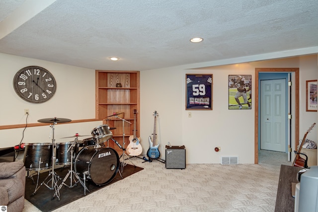 rec room with light carpet and a textured ceiling