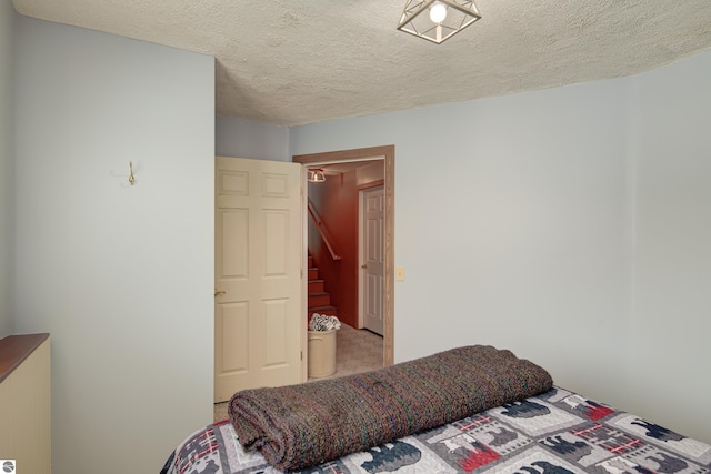 bedroom featuring a textured ceiling and carpet