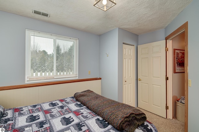 bedroom featuring a textured ceiling, a closet, and carpet floors