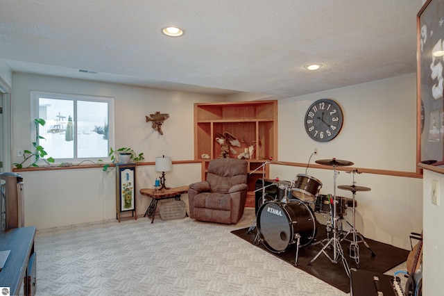 living area featuring light colored carpet and a textured ceiling